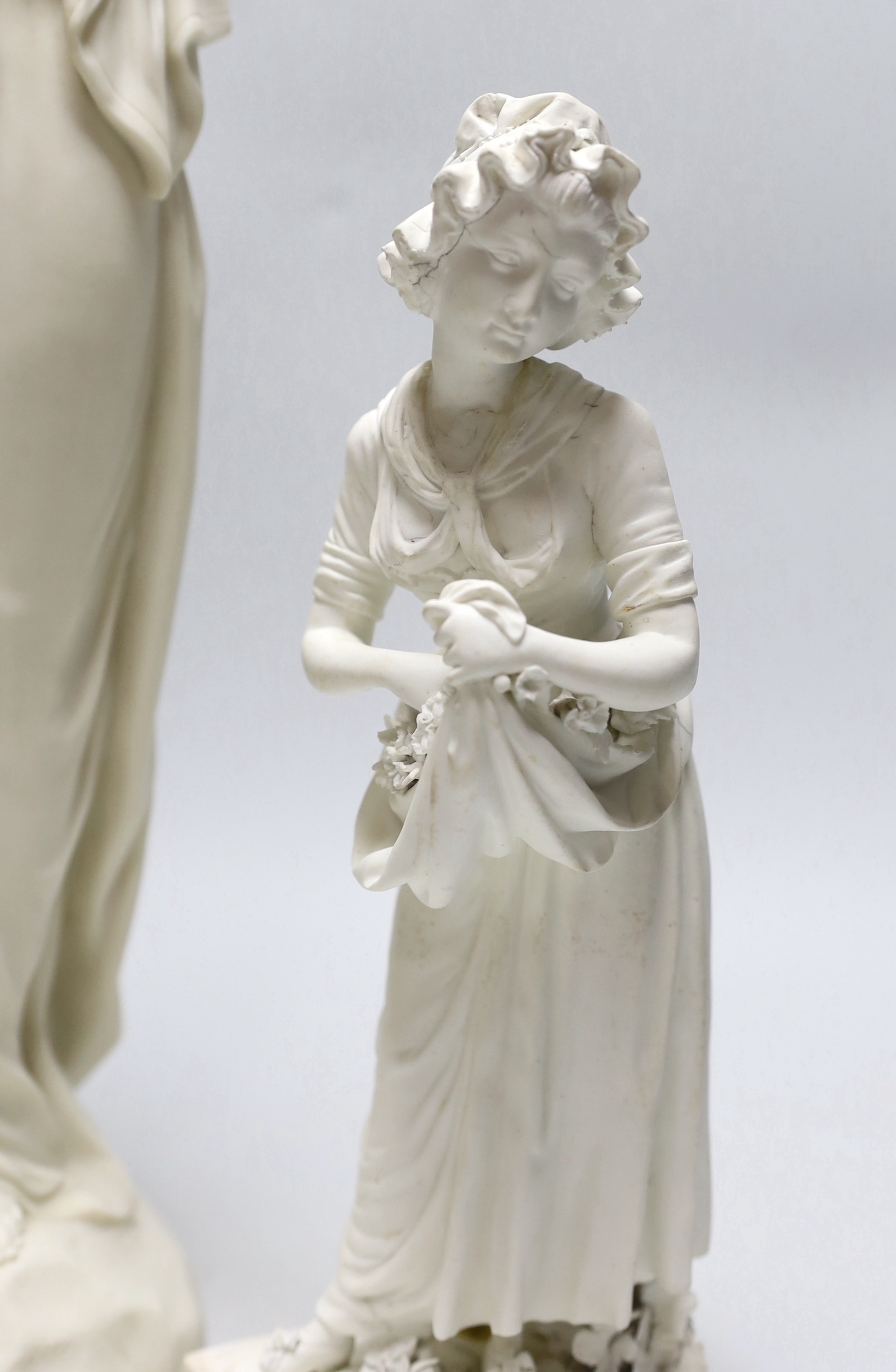 A Derby biscuit figure of a female gardener, c.1780, and a Copeland Parian female figure, the largest 43cm high